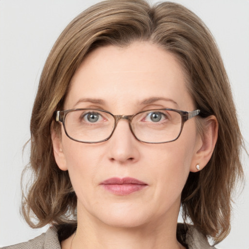 Joyful white adult female with medium  brown hair and grey eyes