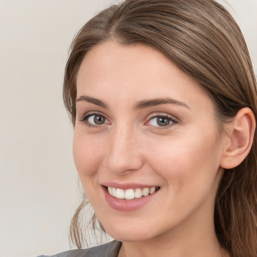 Joyful white young-adult female with long  brown hair and grey eyes