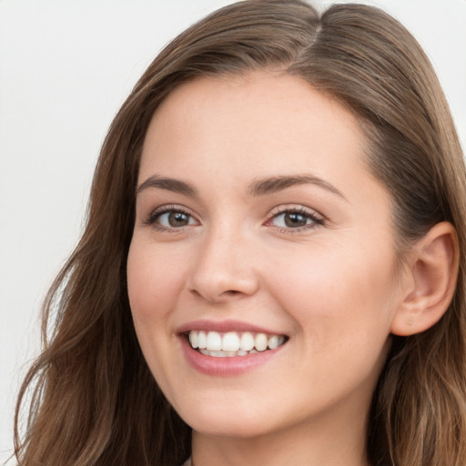 Joyful white young-adult female with long  brown hair and blue eyes