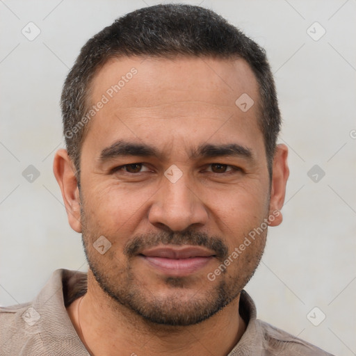 Joyful white adult male with short  black hair and brown eyes