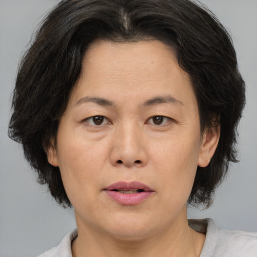 Joyful asian adult female with medium  brown hair and brown eyes
