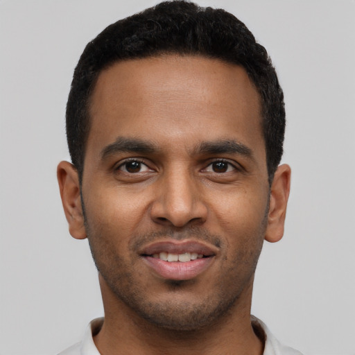Joyful black young-adult male with short  black hair and brown eyes