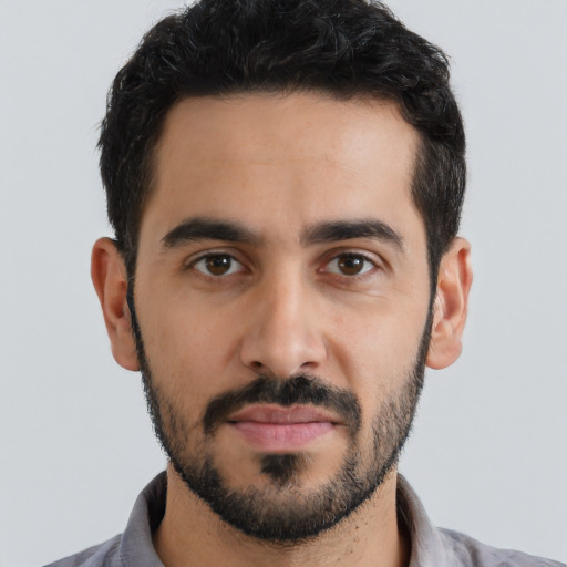 Joyful latino young-adult male with short  black hair and brown eyes