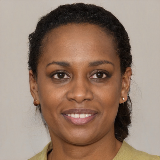 Joyful black young-adult female with medium  brown hair and brown eyes