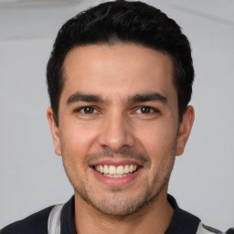 Joyful white young-adult male with short  black hair and brown eyes