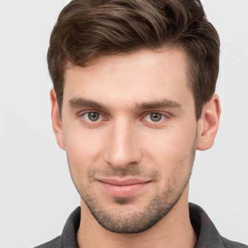 Joyful white young-adult male with short  brown hair and grey eyes