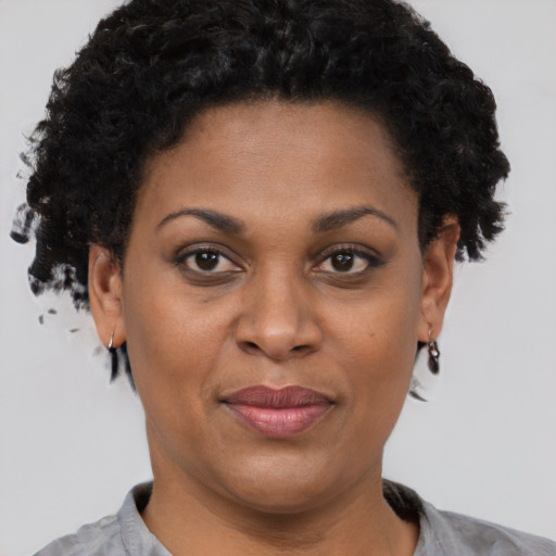 Joyful black adult female with short  brown hair and brown eyes
