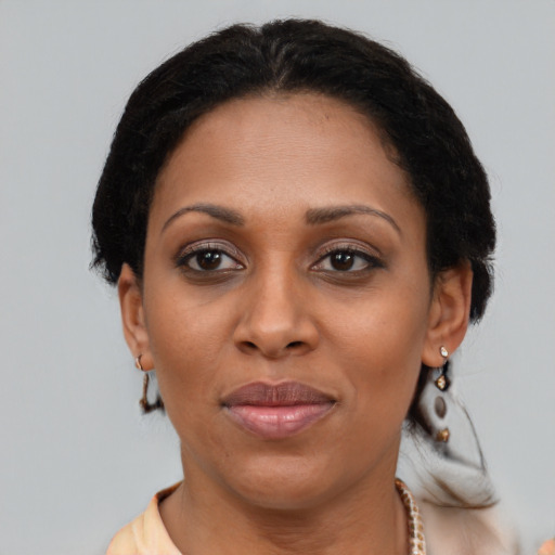 Joyful black adult female with short  brown hair and brown eyes