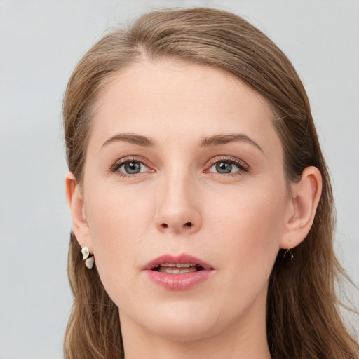 Joyful white young-adult female with long  brown hair and blue eyes