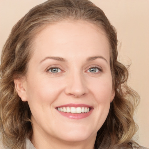 Joyful white young-adult female with medium  brown hair and green eyes