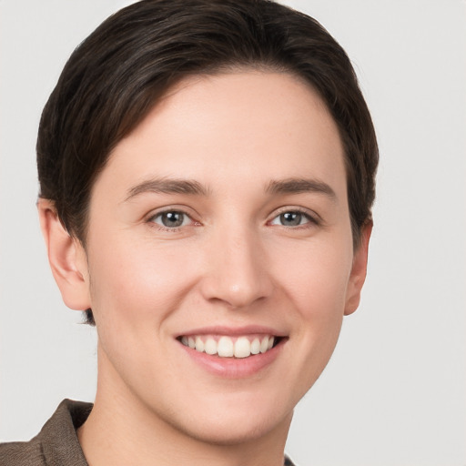 Joyful white young-adult female with short  brown hair and grey eyes