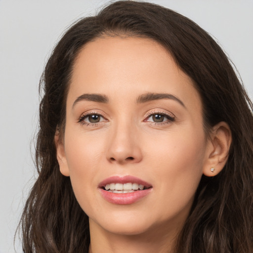 Joyful white young-adult female with long  brown hair and brown eyes