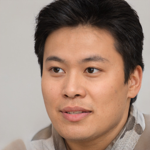 Joyful asian young-adult male with short  brown hair and brown eyes