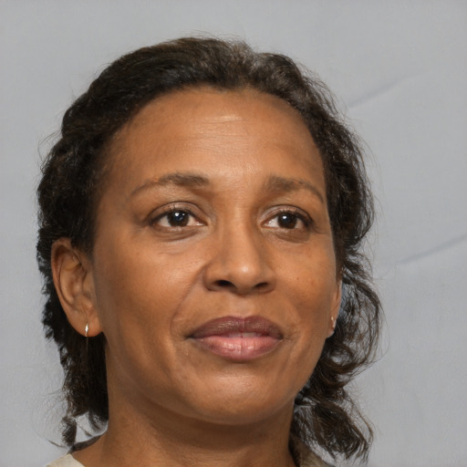 Joyful black adult female with medium  brown hair and brown eyes