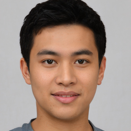 Joyful asian young-adult male with short  black hair and brown eyes