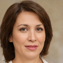 Joyful white young-adult female with medium  brown hair and green eyes