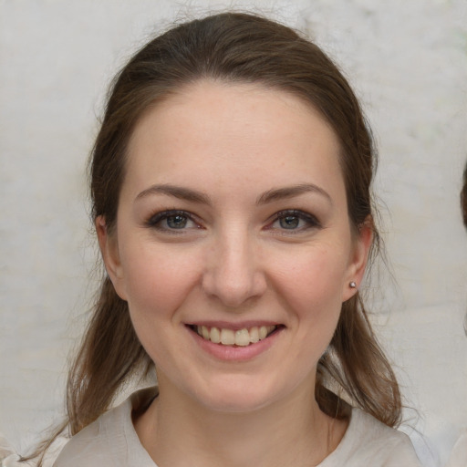 Joyful white young-adult female with medium  brown hair and grey eyes