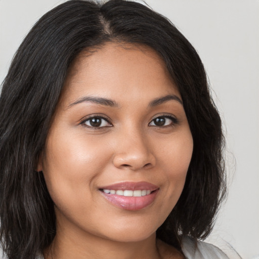 Joyful latino young-adult female with long  brown hair and brown eyes