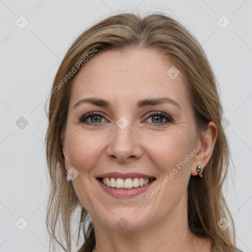 Joyful white adult female with long  brown hair and grey eyes