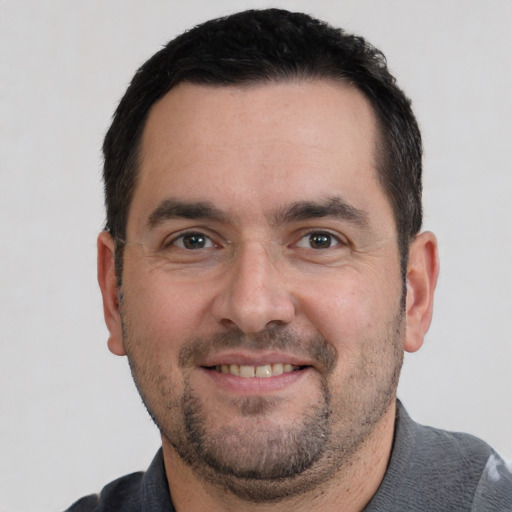 Joyful white adult male with short  black hair and brown eyes