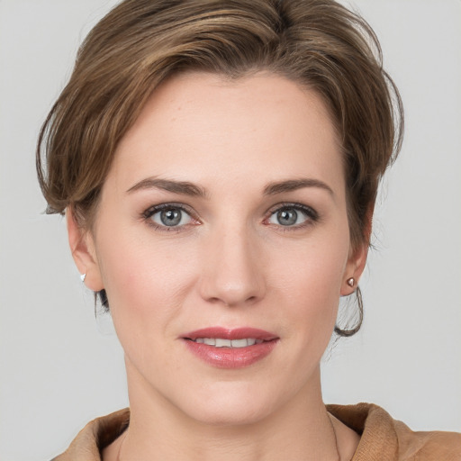 Joyful white young-adult female with medium  brown hair and grey eyes