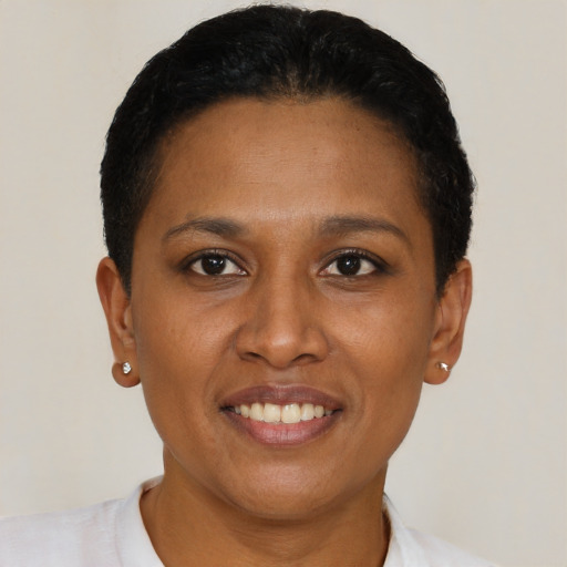 Joyful black adult female with short  black hair and brown eyes