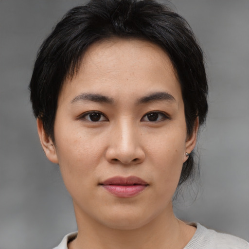 Joyful asian young-adult female with medium  brown hair and brown eyes