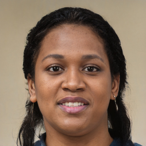 Joyful black young-adult female with long  black hair and brown eyes