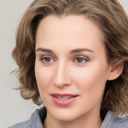 Joyful white young-adult female with medium  brown hair and blue eyes