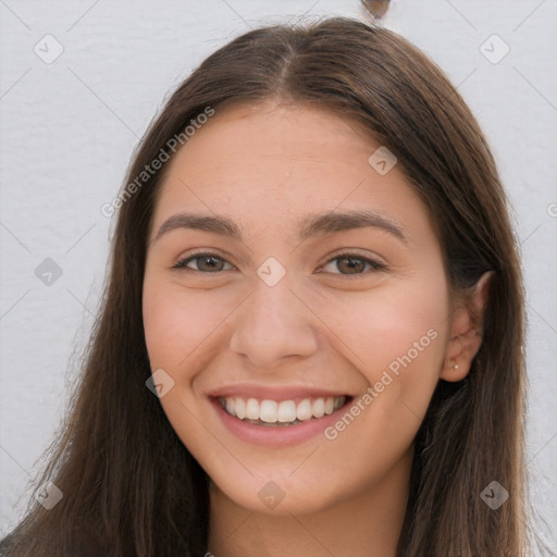 Joyful white young-adult female with long  brown hair and brown eyes