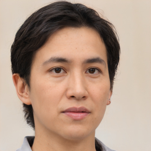 Joyful asian adult male with short  brown hair and brown eyes