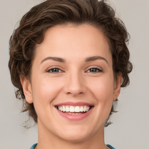 Joyful white young-adult female with short  brown hair and green eyes