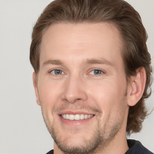 Joyful white adult male with short  brown hair and grey eyes