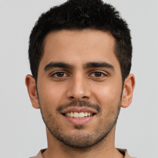 Joyful latino young-adult male with short  brown hair and brown eyes