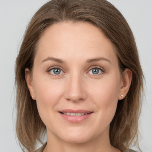 Joyful white young-adult female with medium  brown hair and grey eyes