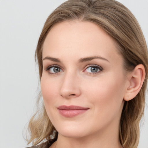 Joyful white young-adult female with long  brown hair and blue eyes