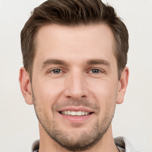 Joyful white young-adult male with short  brown hair and grey eyes