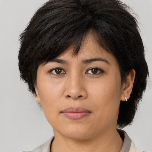 Joyful asian adult female with medium  brown hair and brown eyes