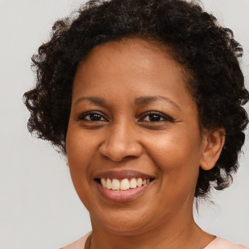 Joyful black young-adult female with medium  brown hair and brown eyes