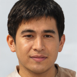 Joyful asian young-adult male with short  brown hair and brown eyes
