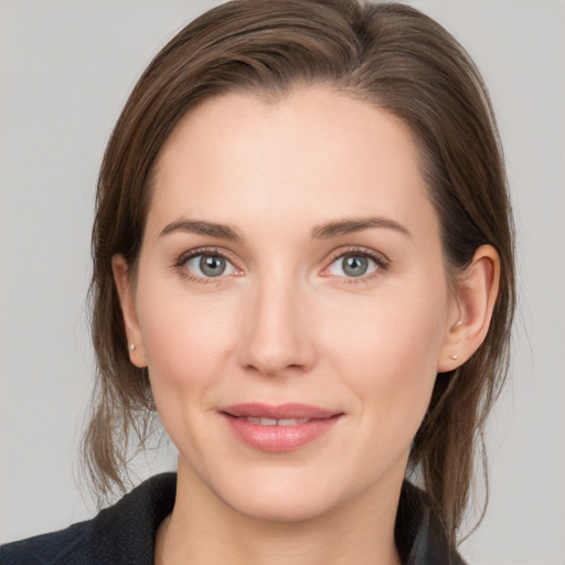 Joyful white young-adult female with medium  brown hair and grey eyes