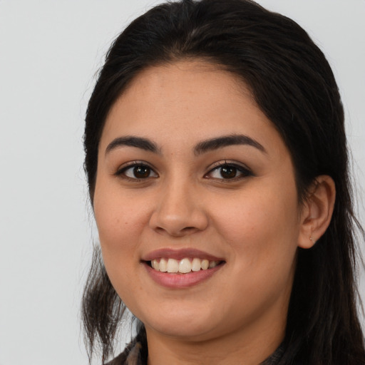 Joyful latino young-adult female with long  brown hair and brown eyes