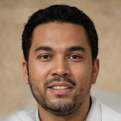 Joyful latino young-adult male with short  black hair and brown eyes