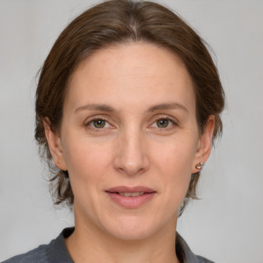 Joyful white adult female with medium  brown hair and grey eyes