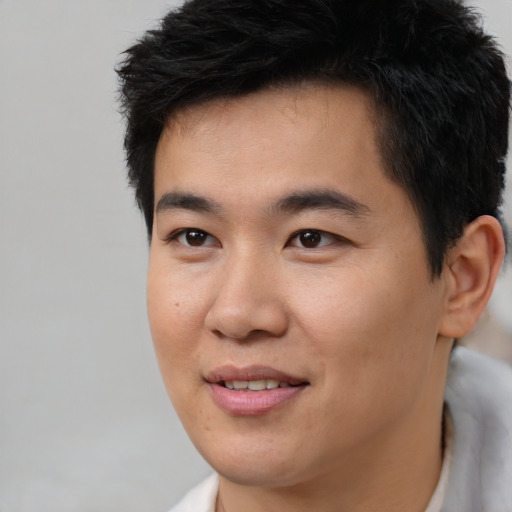 Joyful asian young-adult male with short  brown hair and brown eyes