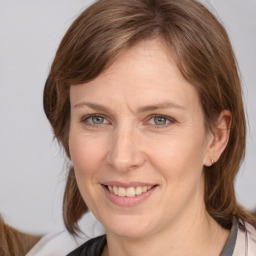 Joyful white adult female with medium  brown hair and grey eyes