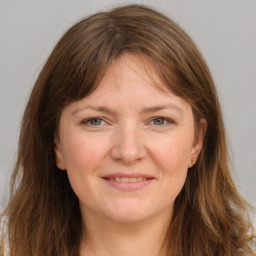 Joyful white young-adult female with long  brown hair and grey eyes