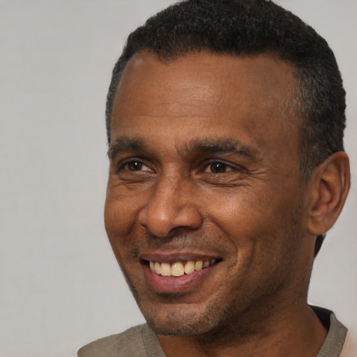 Joyful black adult male with short  brown hair and brown eyes