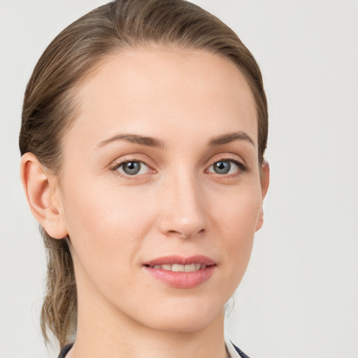 Joyful white young-adult female with medium  brown hair and grey eyes