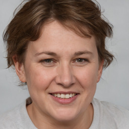 Joyful white adult female with medium  brown hair and blue eyes